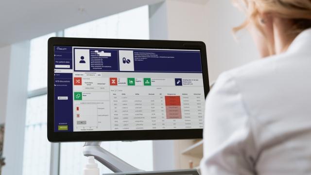 A woman working on a monitor with an analytics platform open