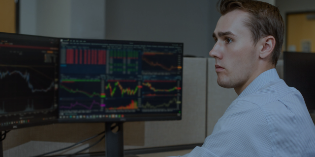Man looking at data visualizations on screens.