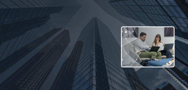 A blue-tinted background of glass skyscrapers with a bright inset photo of two professionals collaborating on laptops.