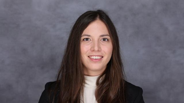portrait photo of Tegan Ashby standing in front of textured gray background