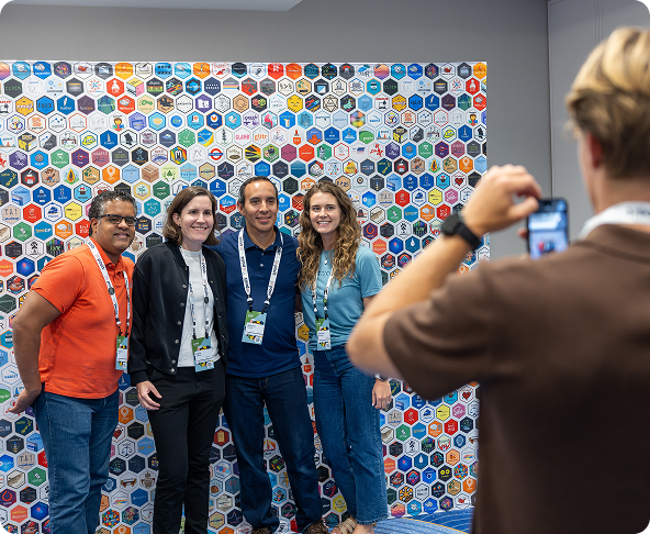 Data scientists taking photo in front of hex wall at Posit::conf()