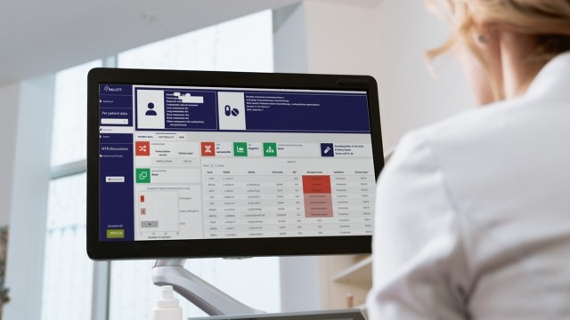 A woman working on a monitor with an analytics platform open