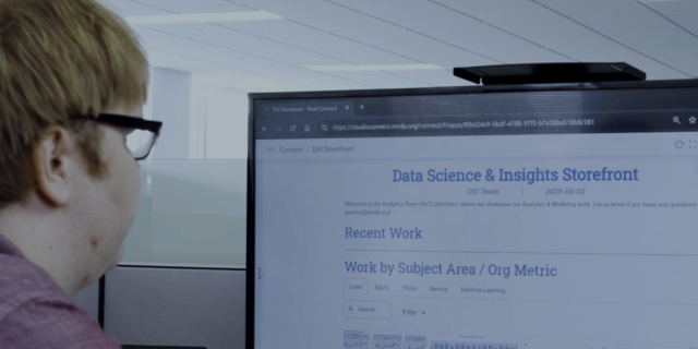 A man looking at a monitor that reads "Data Science and Insights Storefront"