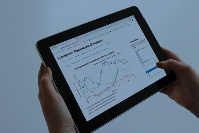 A tablet screen displaying a complex line graph from the Emergency Department Solutions Suite, tracking patient flow and ER metrics.