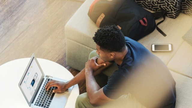An overhead photo of a statistician working on an R programming exercise on his laptop during a PSI training course.