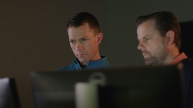 Two men look at a monitor