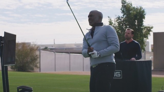 Man holding a golf club after swinging