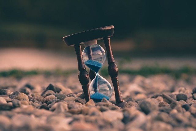 An hourglass on a rocky beach