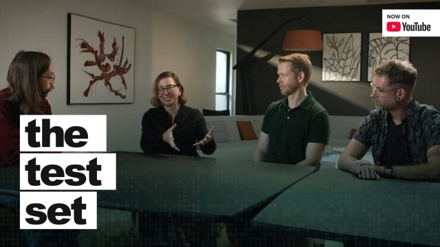 Four people sitting around a table with a title overlay, "the test set."