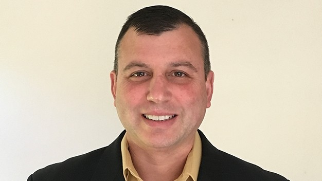 portrait of Bryan Butler in front of cream colored wall