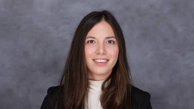 portrait photo of Tegan Ashby standing in front of textured gray background