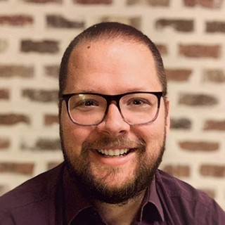 portrait of Matthias Mueller smiling in front of brick wall