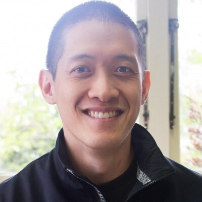 portrait of Winston Chang in front of windows facing trees