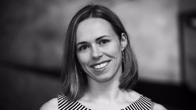 black and white portrait of Elaine McVey smiling in front of blurred background