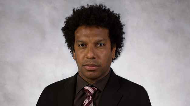 portrait of Kobi Abayomi in front of textured gray wall