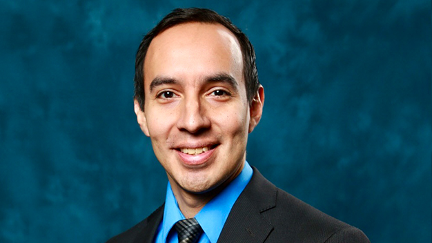 portrait of Marcos Huerta in front of dark blue textured background
