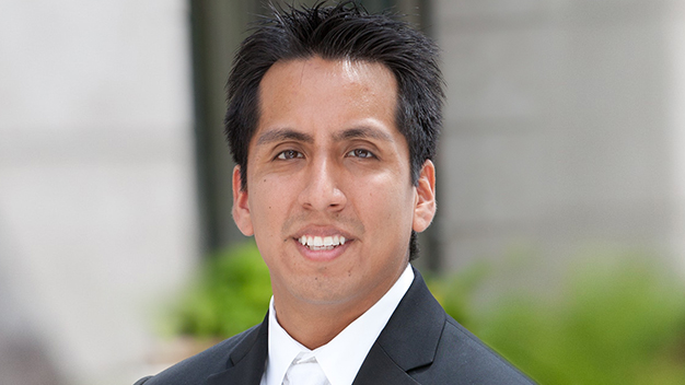 portrait of Matthew Montero outside in front of building with greenery