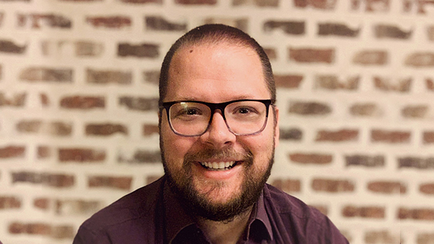 portrait of Matthias Mueller smiling in front of brick wall