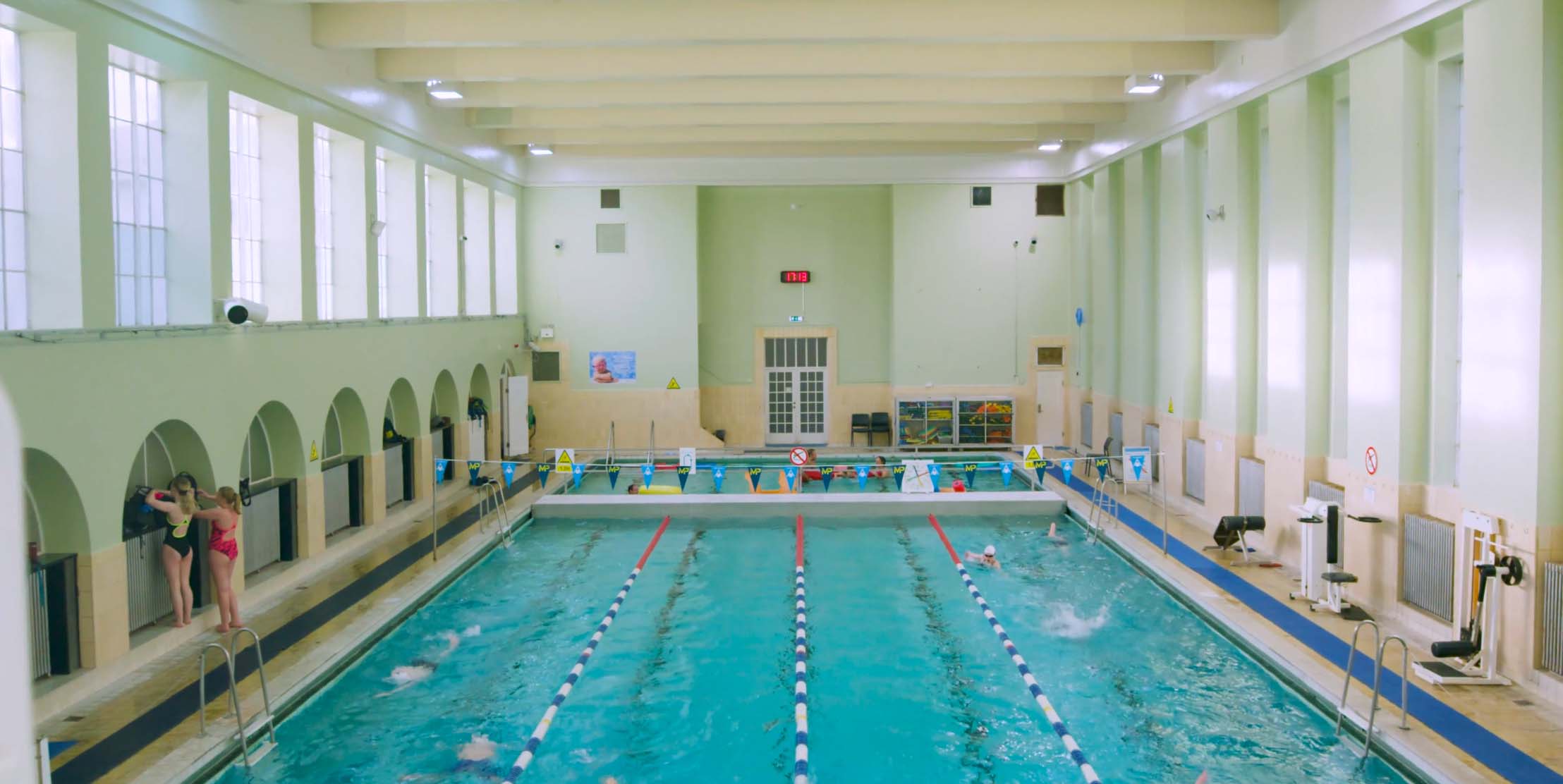 wide shot of indoor swimming pool with swimmers practicing