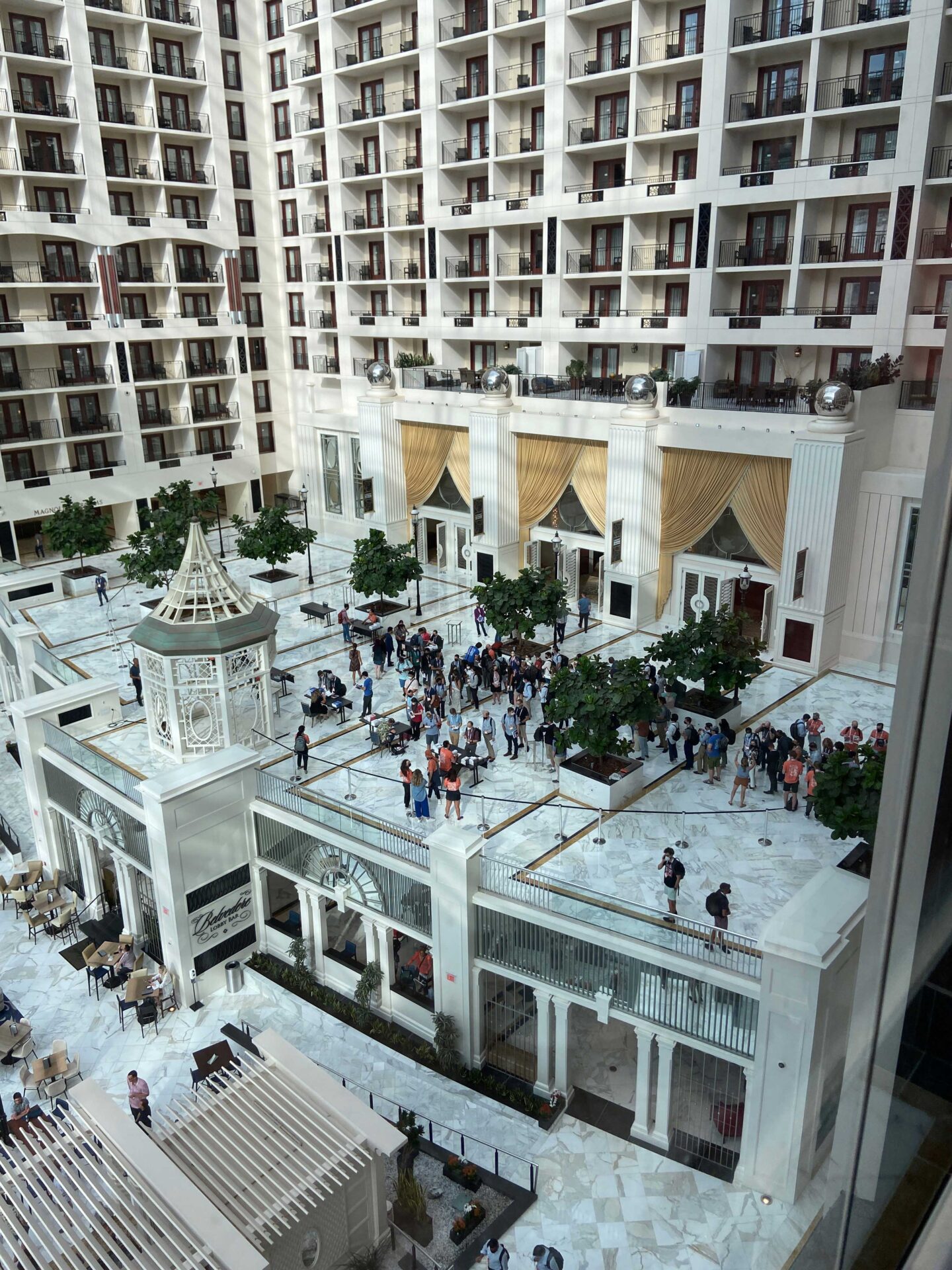 aerial view of crowd gathered in bright atrium area of large hotel