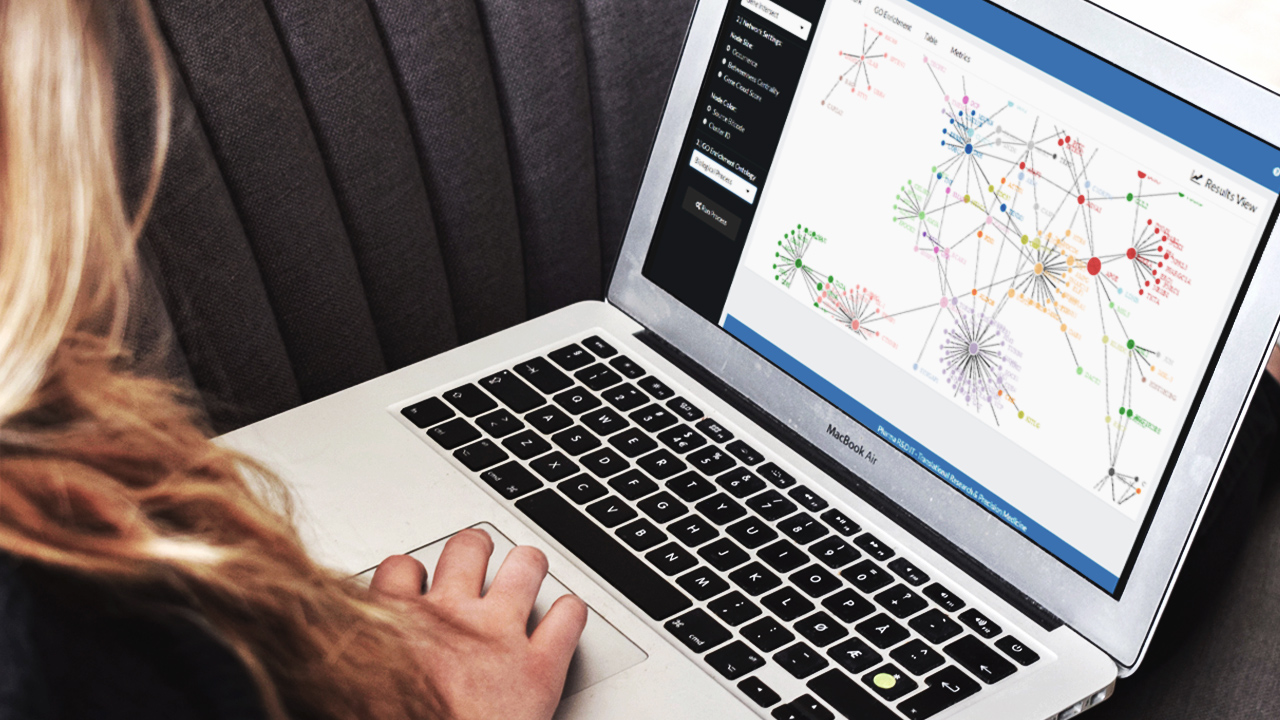 woman looks on laptop at a hub and spoke network graph from a Shiny app