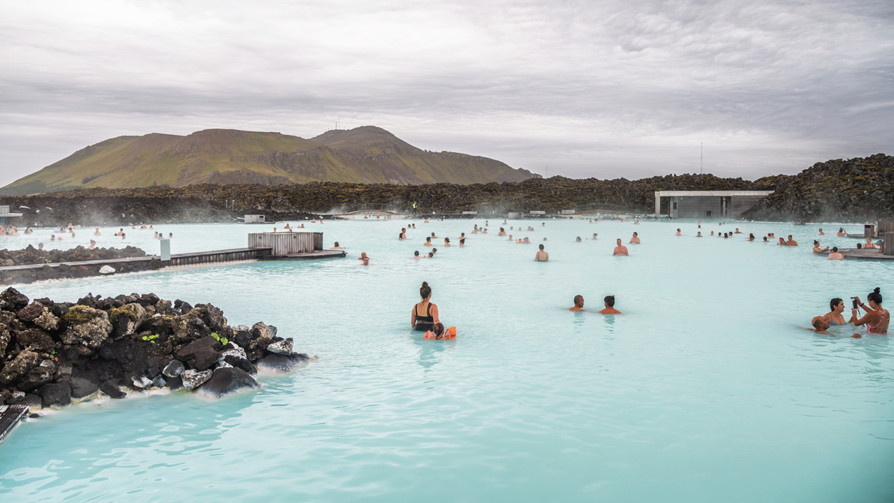 wide shot of people enjoying a geothermic pool in Iceland