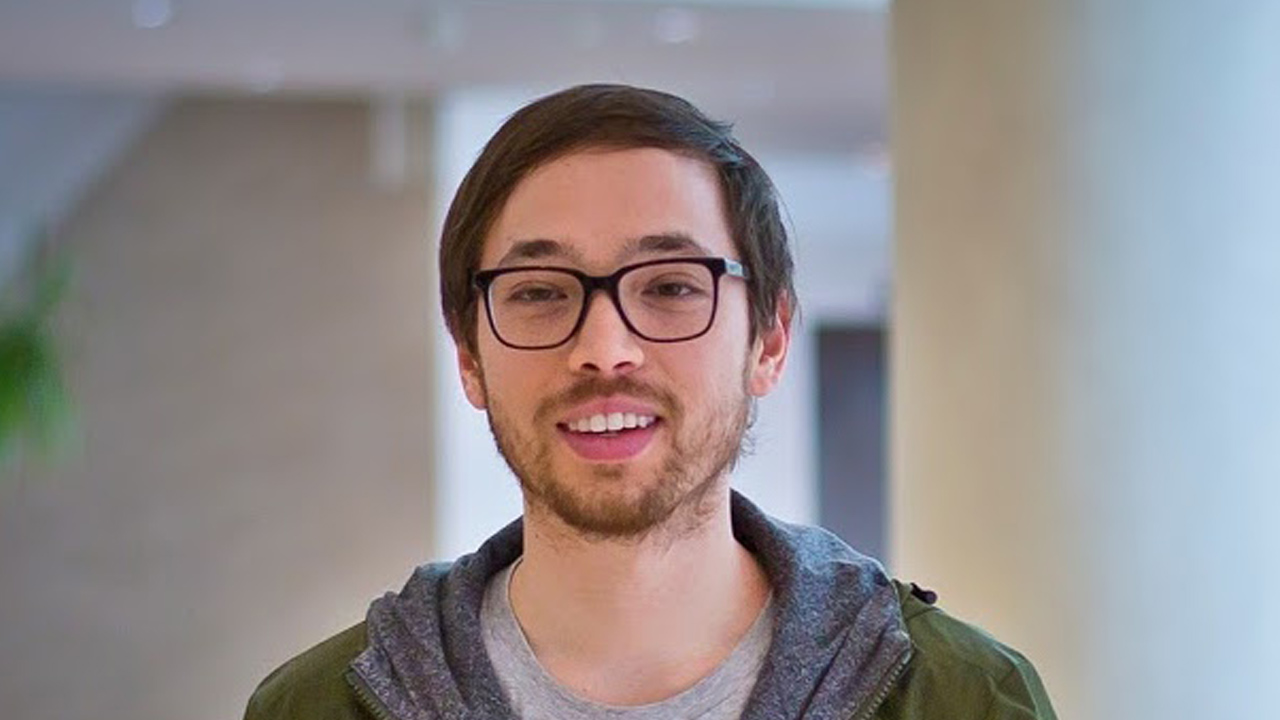 portrait of Michael Chow smiling while standing in large, modern room