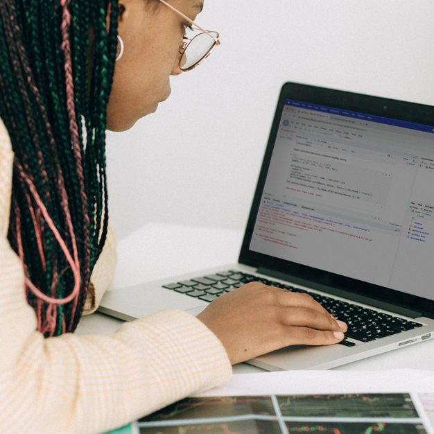 A woman looks at code on her laptop