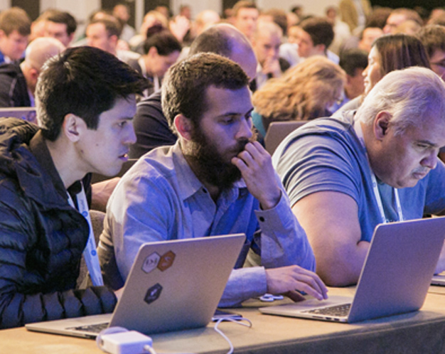 Many people sitting front of computers at a workshop event