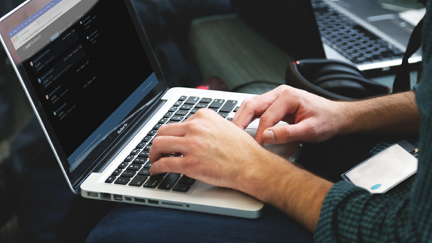 Man on laptop with Posit Workbench interface on screen