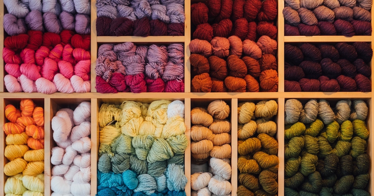 Skeins of yarn in a variety of colors neatly stacked