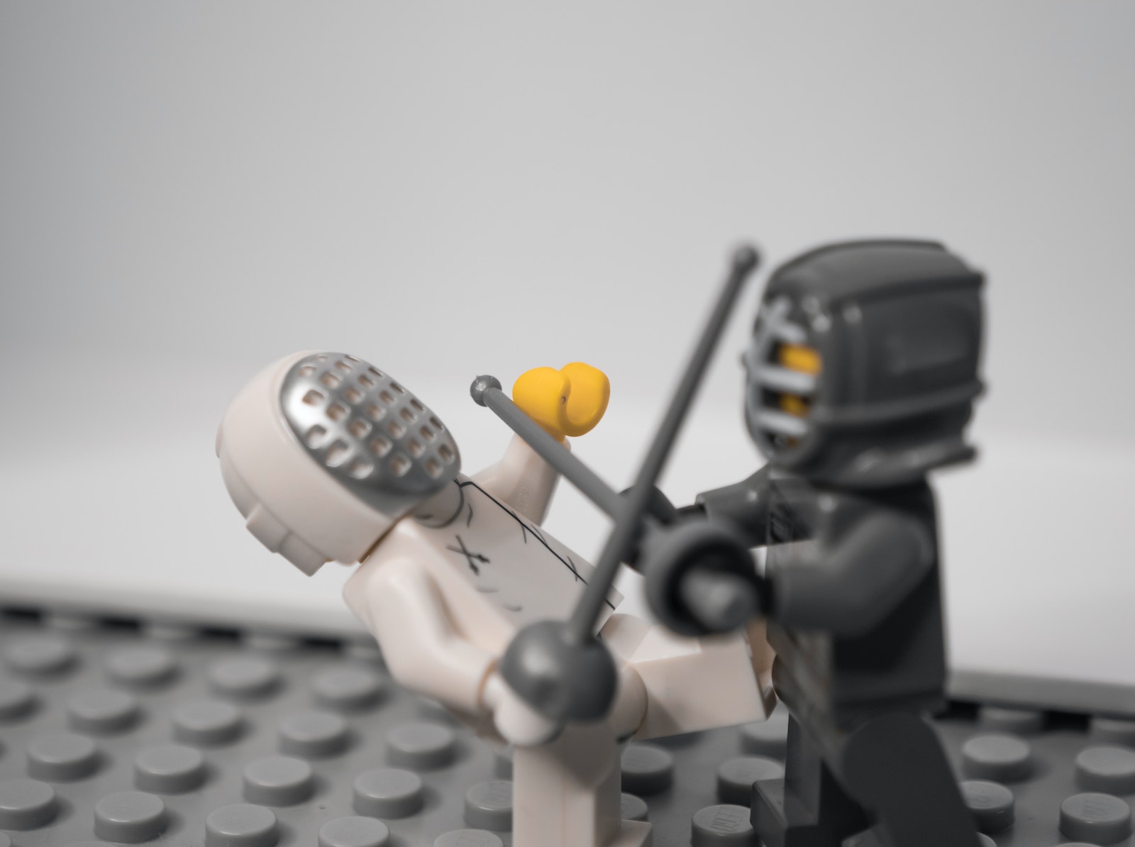 two lego men dueling with swords