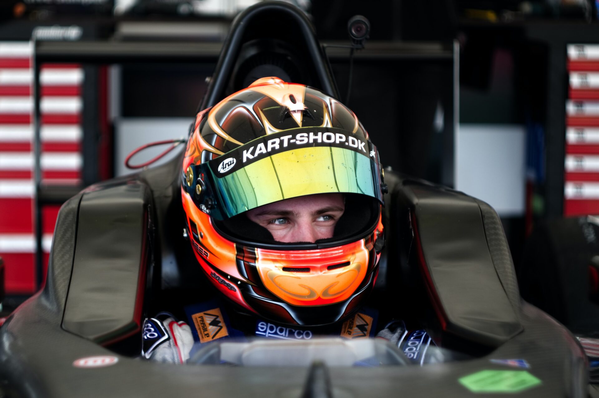 a photo of a race car driver smiling in his car